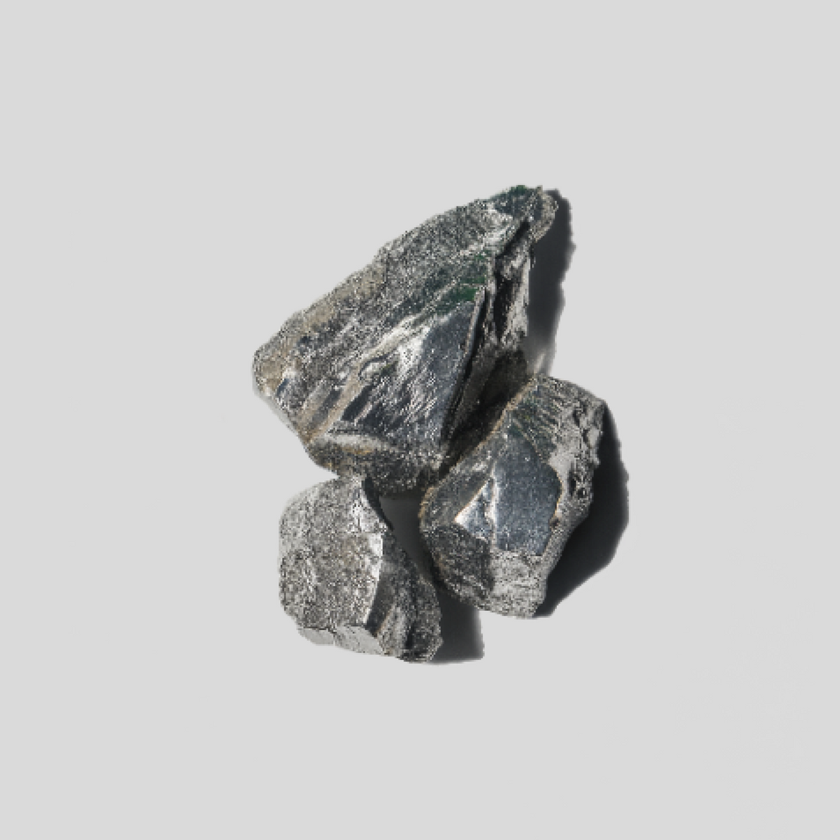 Three rough metallic rocks on a light gray background